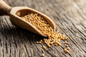 Yellow,Mustard,Seeds,In,Wooden,Spoon,On,Old,Wooden,Table.